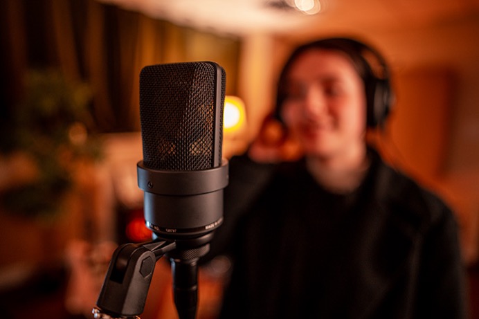 Attractive female singing into Neumann TLM 103 at Material Studios